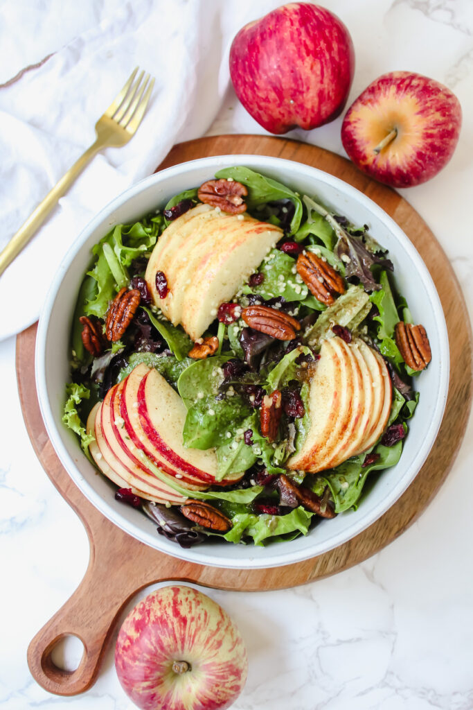 overview shot of apple cinnamon salad with dressing drizzled on top