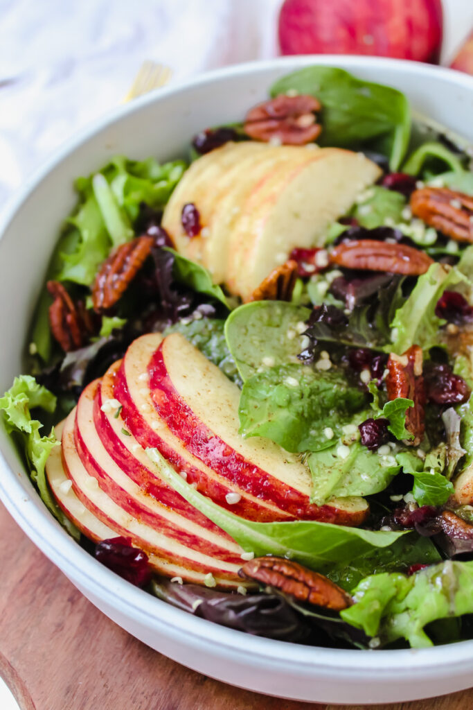 angled close up shot of salad with sliced apples