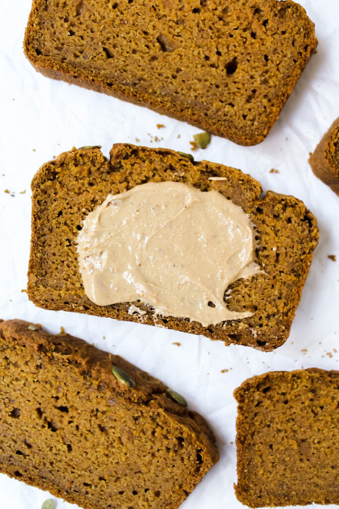 close up shot of pumpkin bread slice with nut butter on top