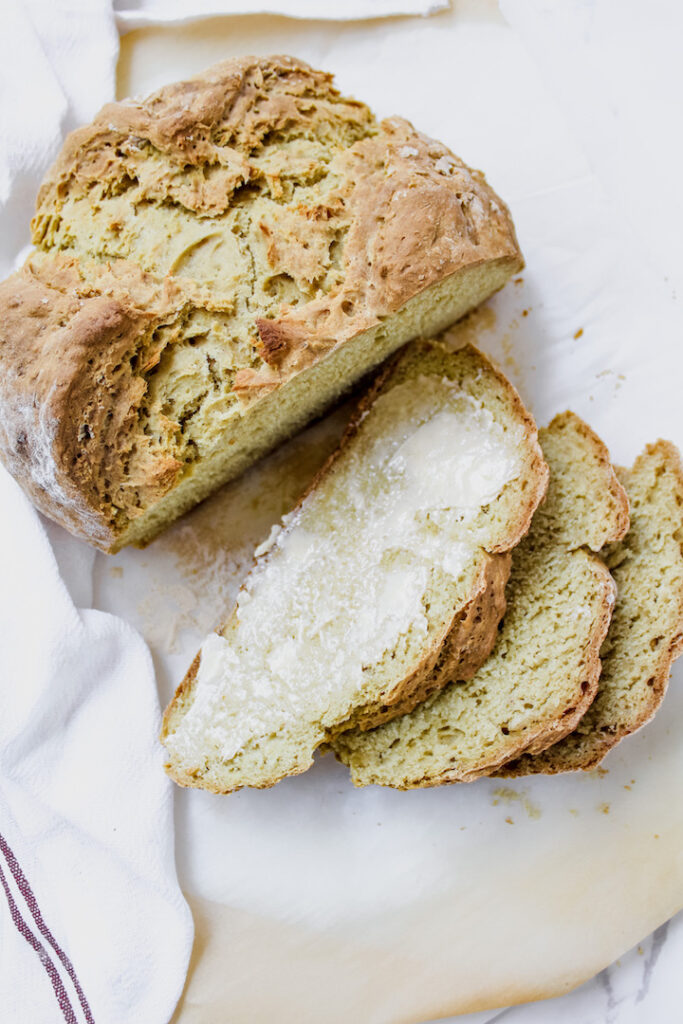 overview shot of sliced bread with butter on one slice