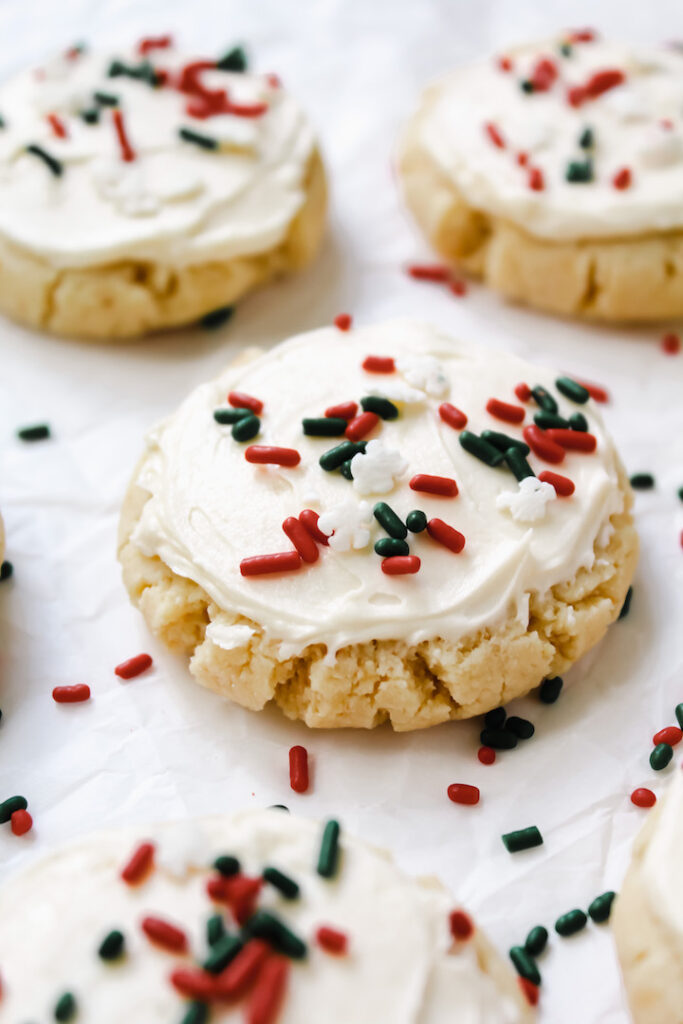 close up angled shot of sugar cookies with frosting and sprinkles