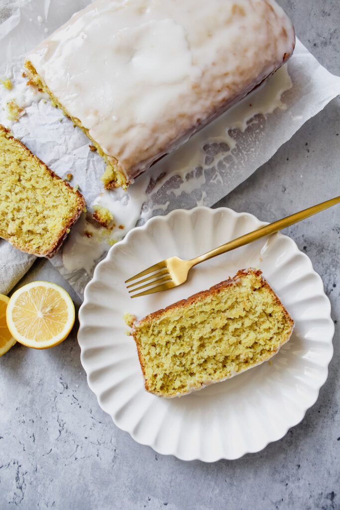 overview shot of a slice of vegan starbucks copycat lemon loaf on a plate with a fork on the side