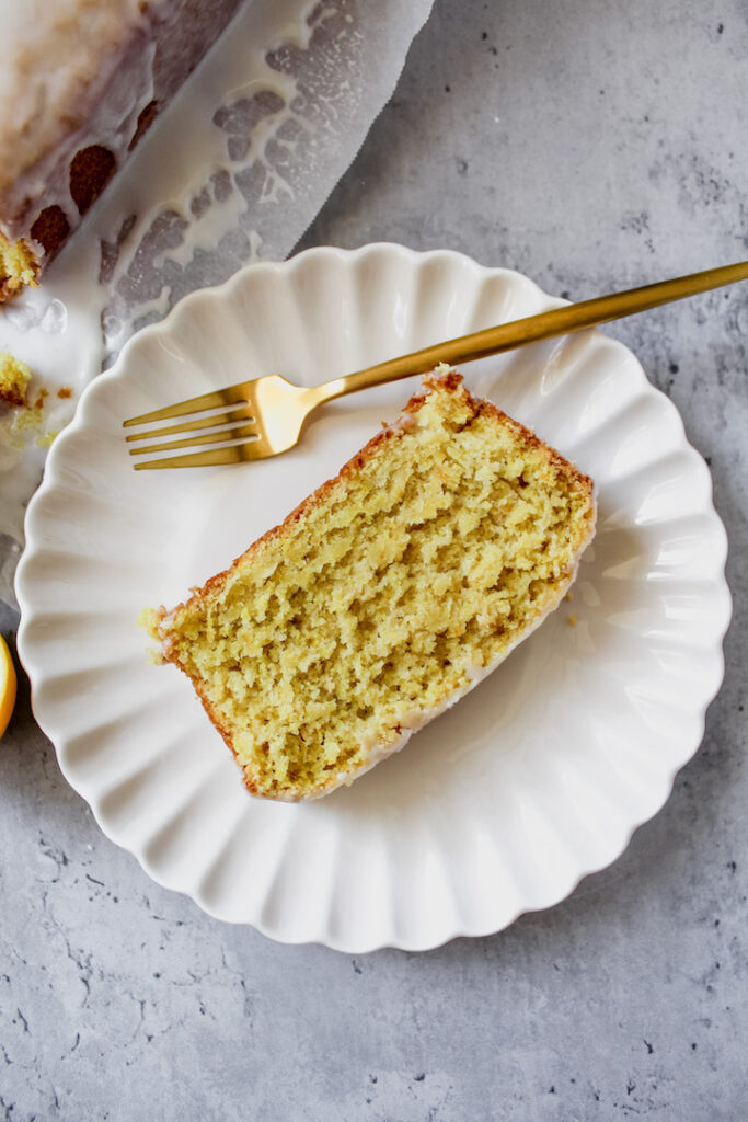 overview shot of a slice of vegan starbucks copycat lemon loaf on a plate with a fork on the side