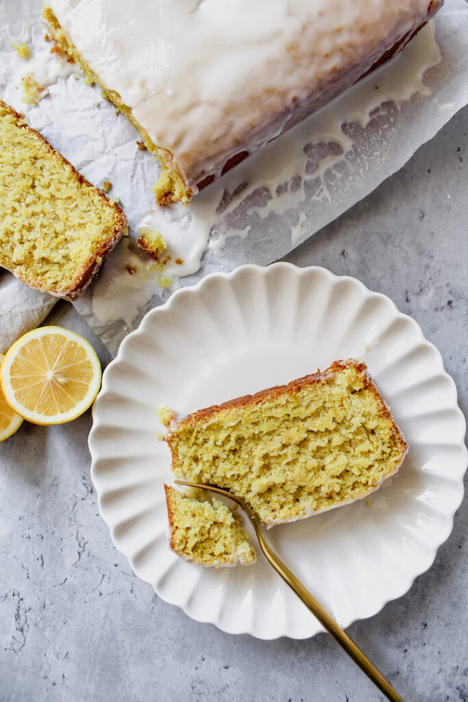 overview shot of a slice of lemon loaf on a plate with a corner cut