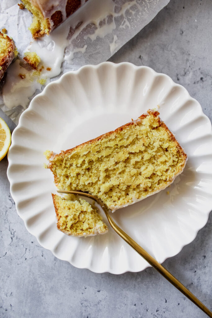 overview shot of a slice of lemon loaf on a plate with a corner cut