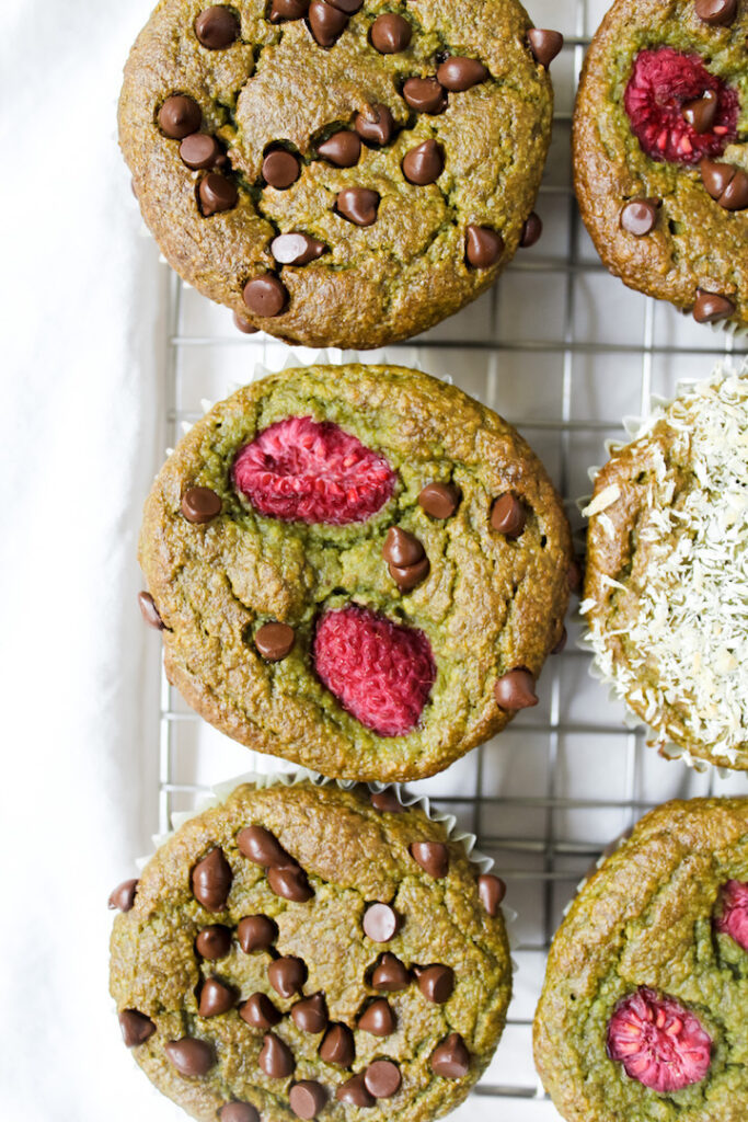 close up overview shot of spinach banana muffin with raspberries and chocolate chips on top