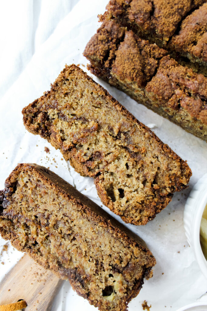 shot of two slices of banana bread laying flat on a cutting board