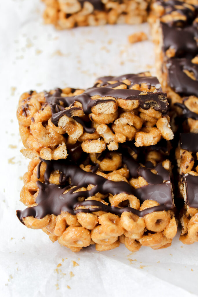 two peanut butter chocolate protein cheerio bars stacked on top 