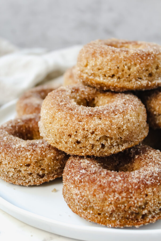 side view of baked vegan apple cider donuts on a plate 