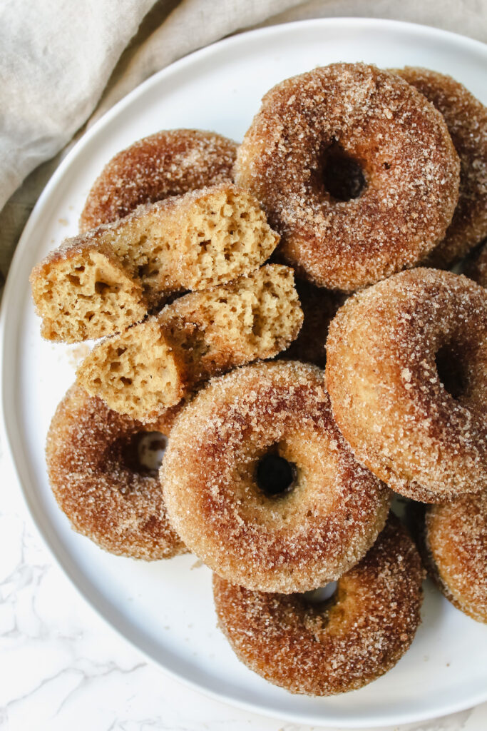 plate of donuts with one donut broken in half