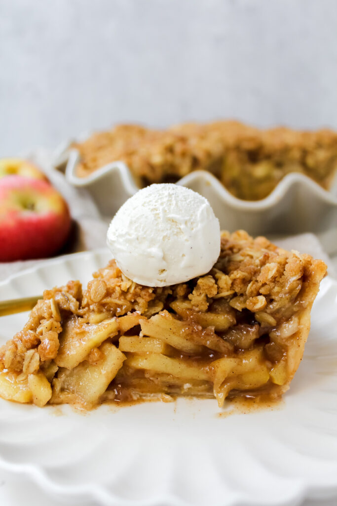 side view shot of a slice of apple pie with ice cream on top