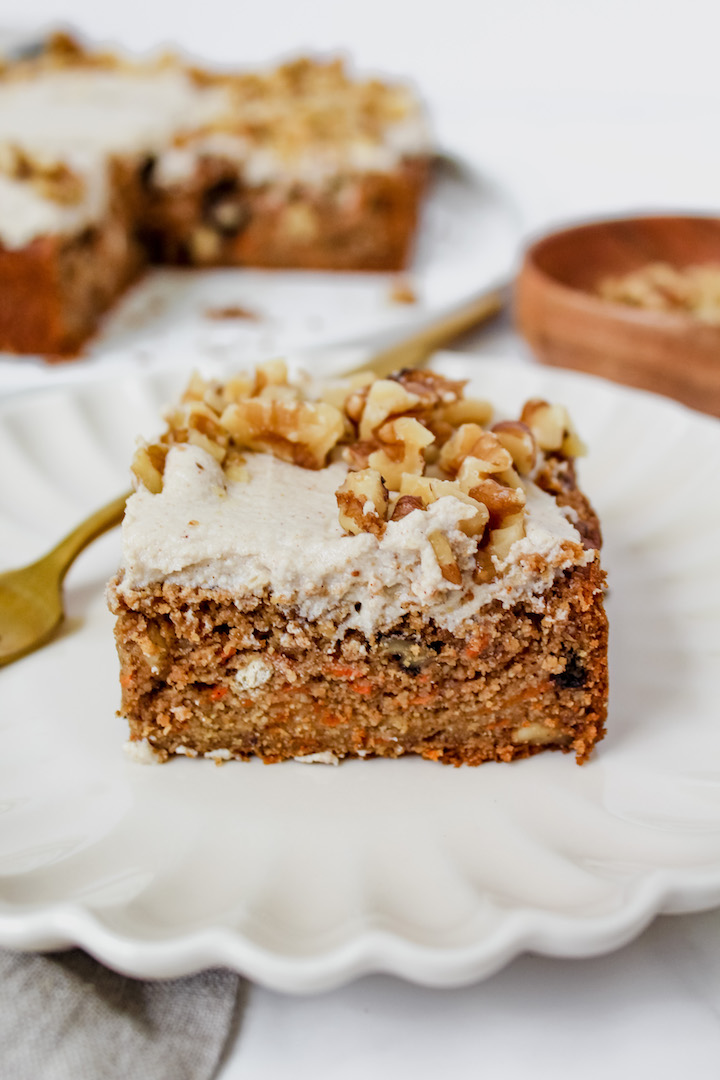 angled shot of a slice of the best healthy carrot cake on a plate