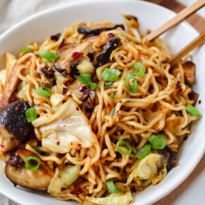 shot of ramen noodles in a bowl with chopsticks in it