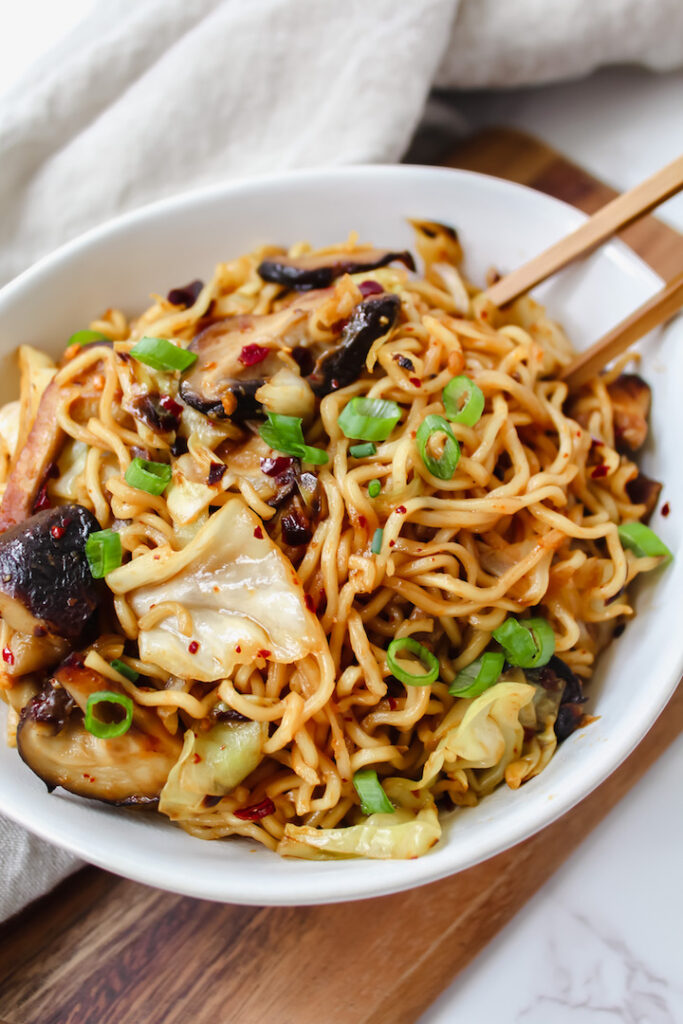 shot of ramen noodles in a bowl with chopsticks in it