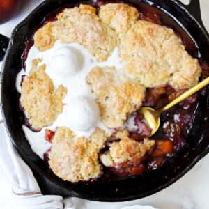 overview shot of vegan blackberry peach cobbler with a scoop taken out