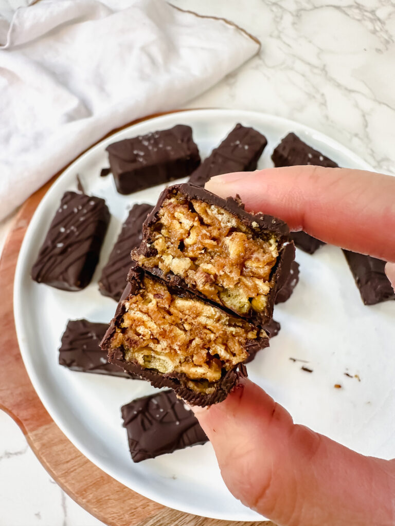 hand holding a butterfinger cut in half