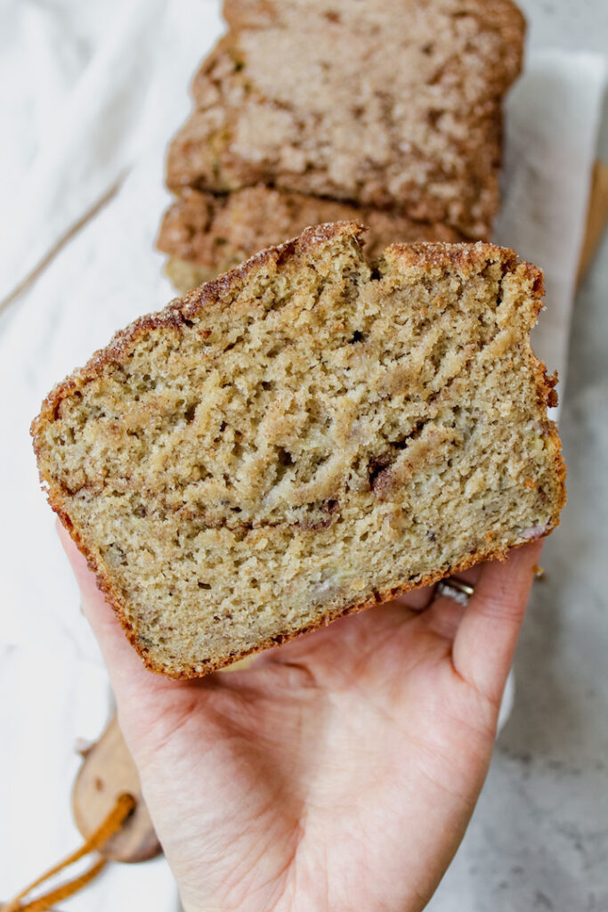 hand holding a slice of sourdough snickerdoodle banana bread