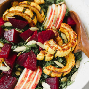 close up shot of salad with wooden salad tongs