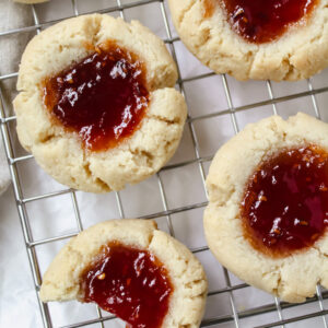 overview shot of thumbprint cookies with a bite taken out of one cookie