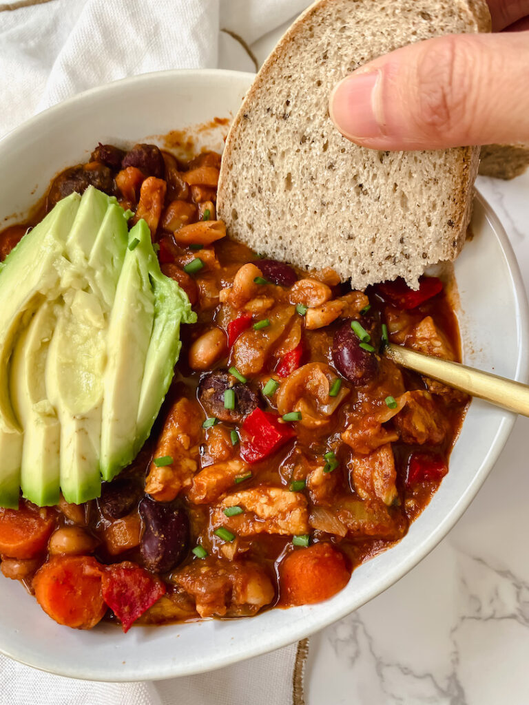 dipping bread into the tempeh chili