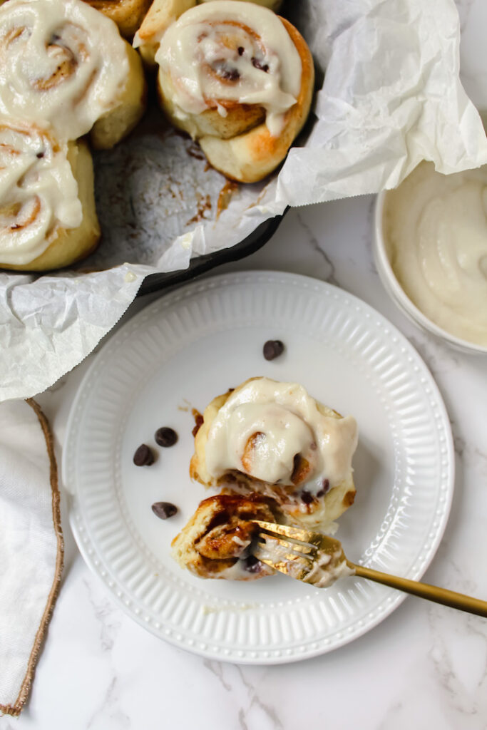 overview shot of a piece of cinnamon roll on a plate with a bite on a fork