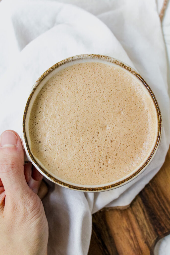 close up of hand holding hot chocolate filled mug