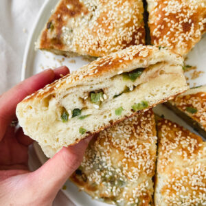 hand grabbing a slice of scallion bread