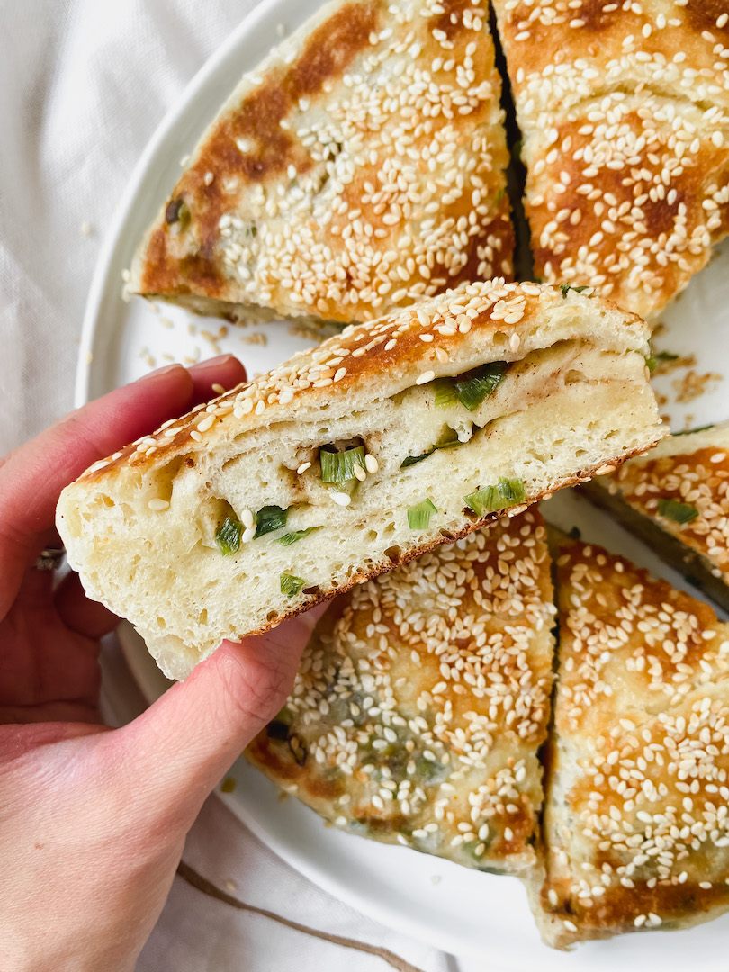 hand grabbing a slice of scallion bread