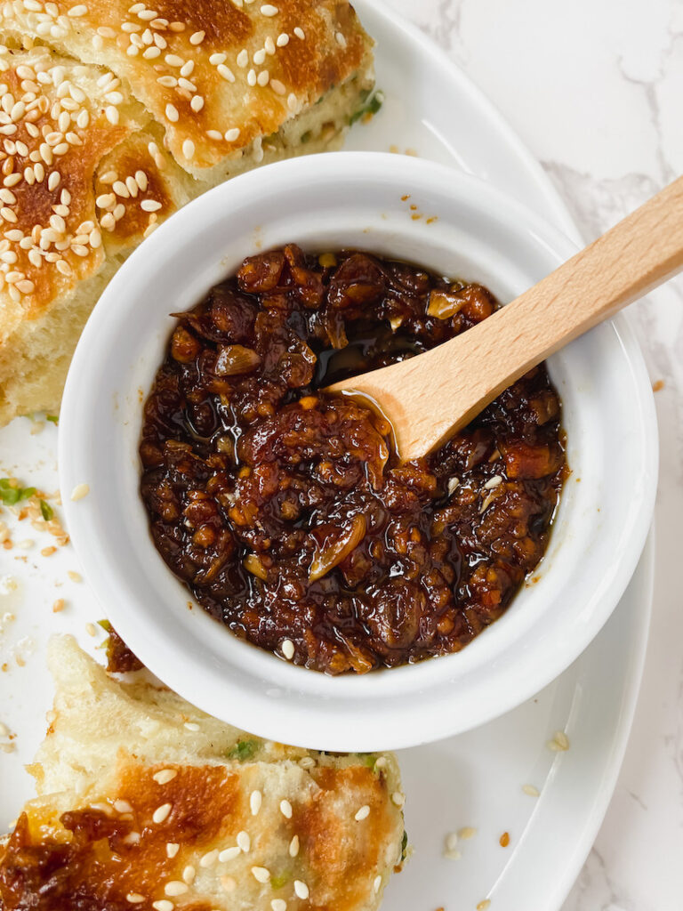 close up of XO sauce with a wooden spoon in it