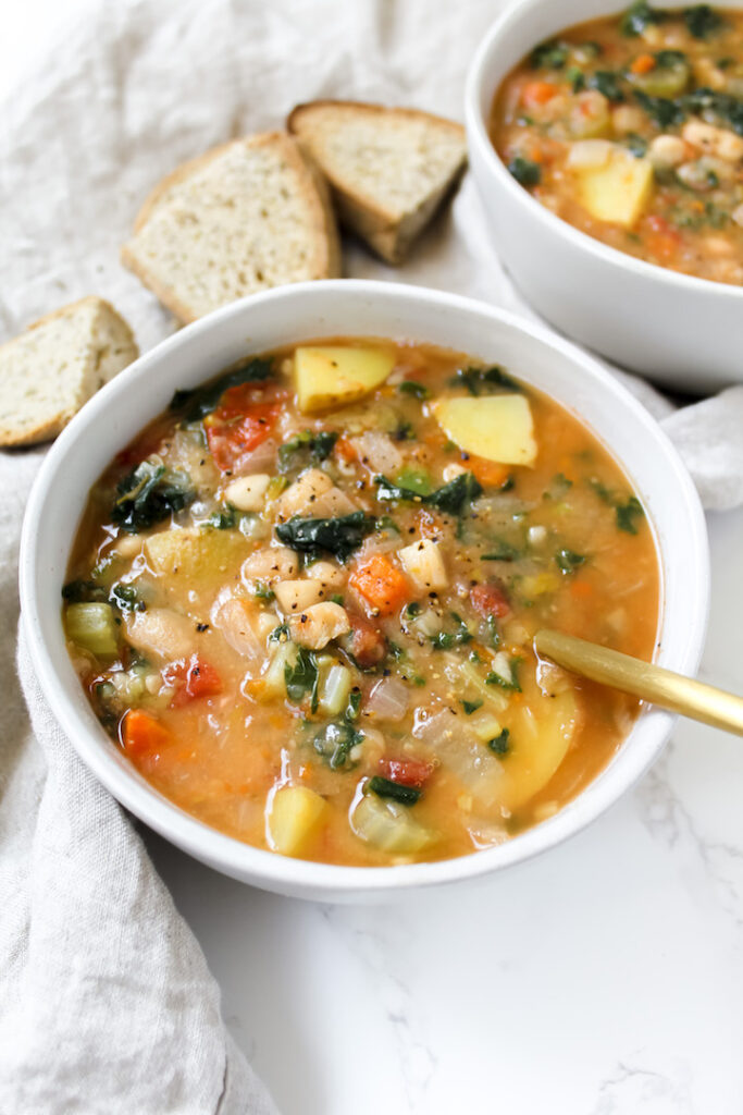 angled shot of a bowl of tuscan white bean and kale soup