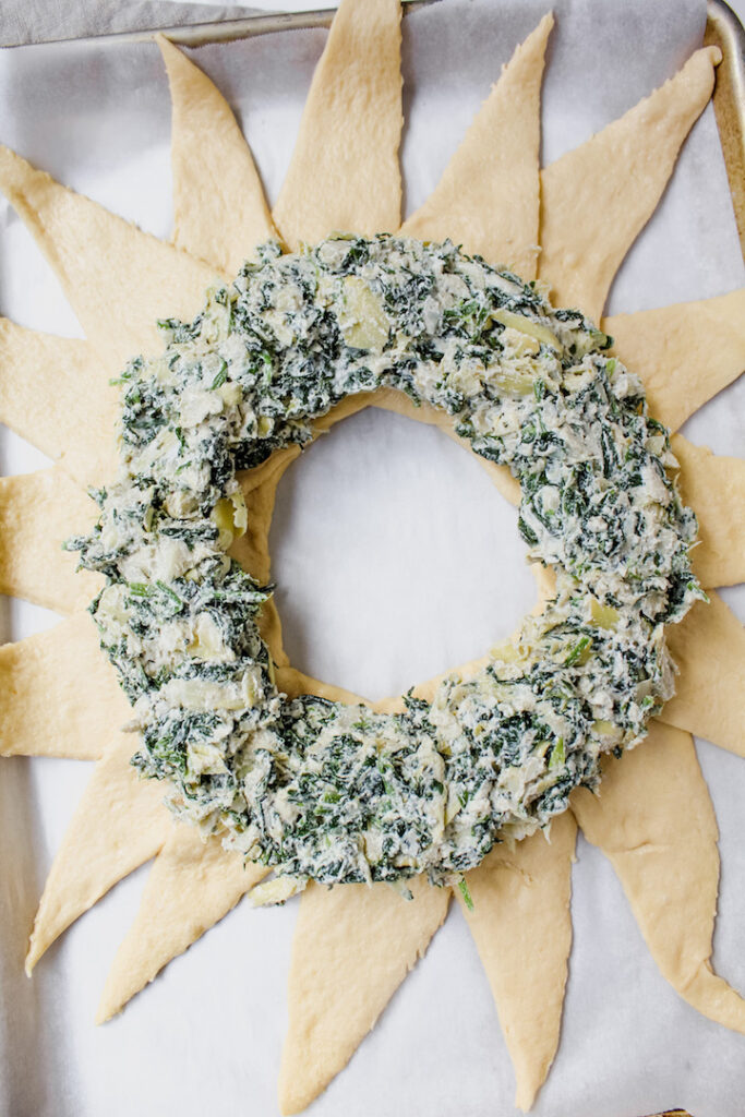 picture of the spinach artichoke filling on top of dough before baking