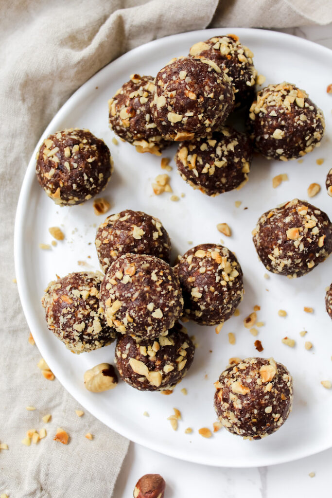 photo of healthy homemade ferrero rocher balls stacked on top of each other in a pyramid on a white plate