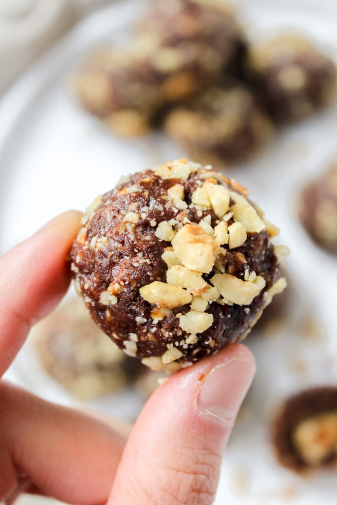 close up of fingers holding a ferrero rocher ball