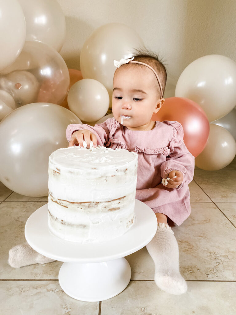 Sophie touching the frosting of the smash cake