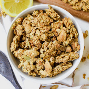 overview shot of bowl of granola with lemon slices on the side and granola on the sides