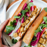 hand grabbing one tofu banh mi