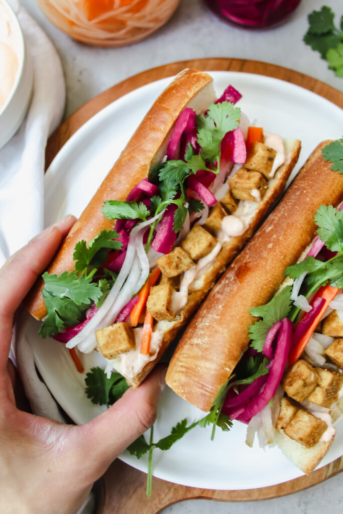 hand grabbing one tofu banh mi