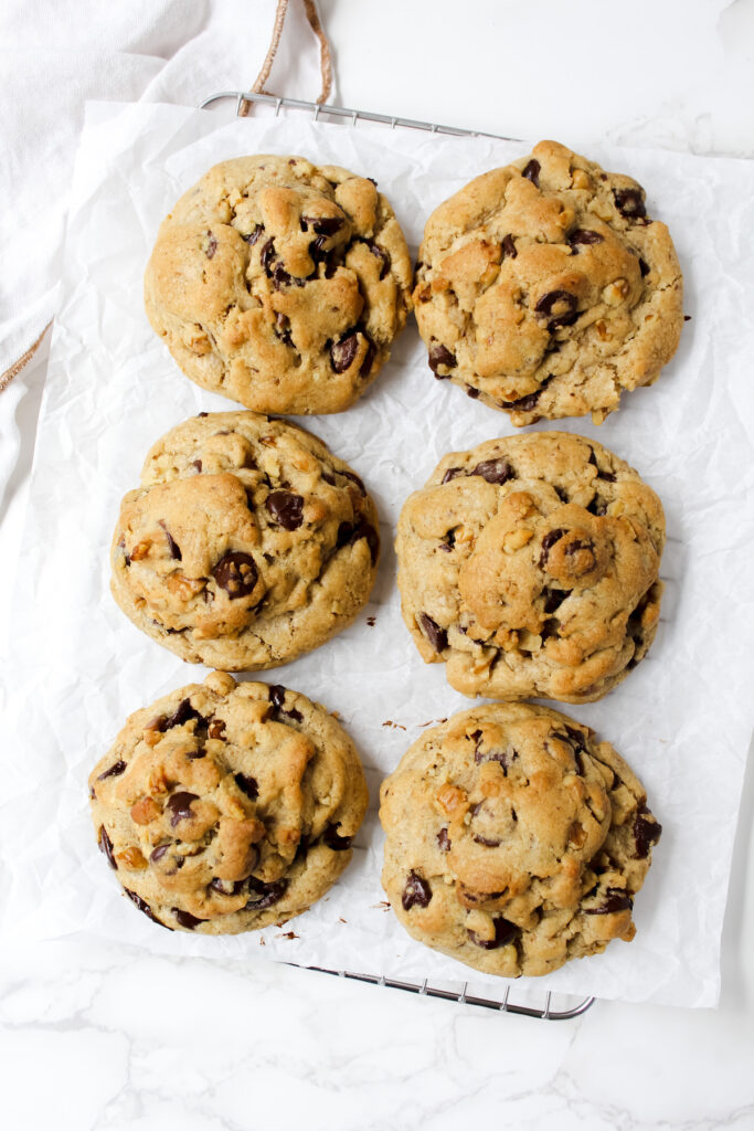 overview shot of all the levain bakery chocolate chip cookies on parchment paper