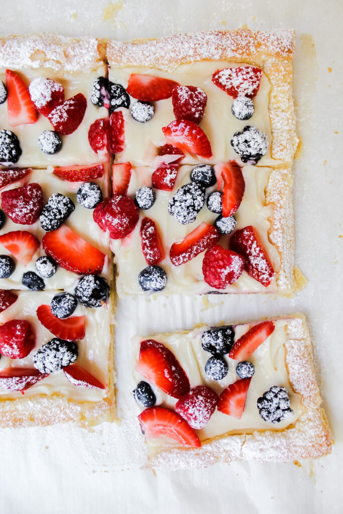 one slice of vegan berry cheesecake puff pastry tart pulled out from the group