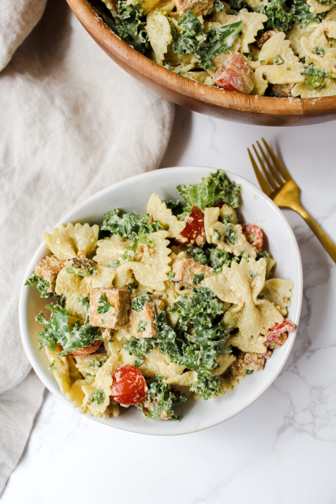 overview shot of a white bowl with pasta salad in it