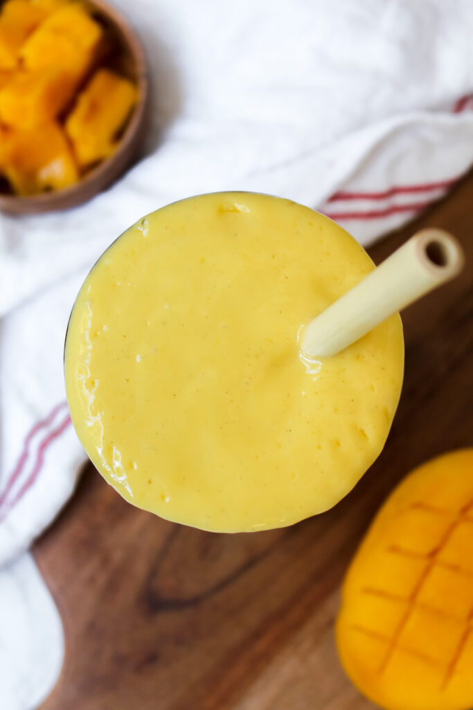 top view shot of mango lassi with a straw in the cup