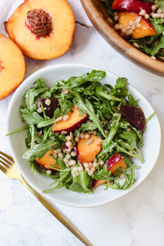 overview shot of salad in a white bowl with gold spoon