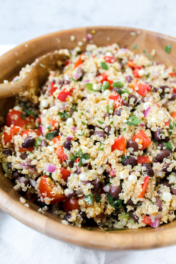 angled shot of wooden bowl with quinoa salad