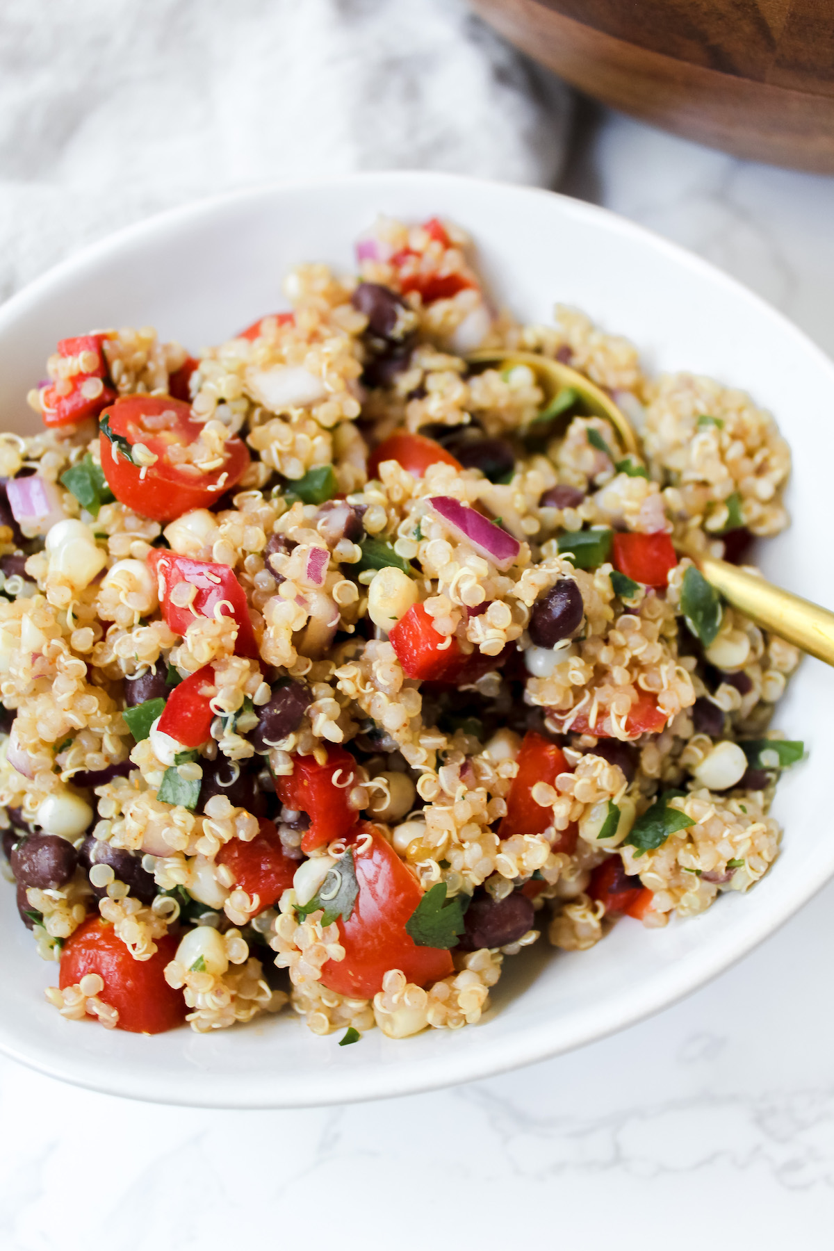 close up of quinoa salad in a bowl with spoon