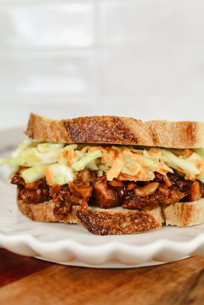 angled shot of bbq jackfruit sandwich with avocado slaw