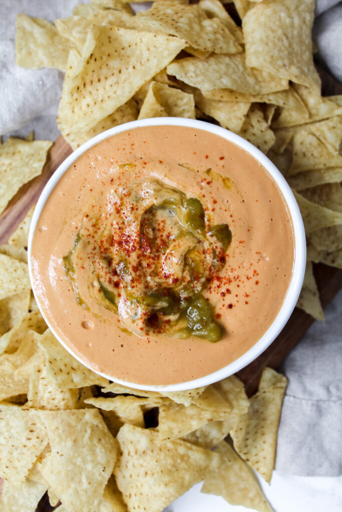 close up shot of queso with chips on the side