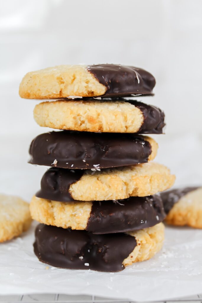 a tall stack of chocolate dipped coconut cookies