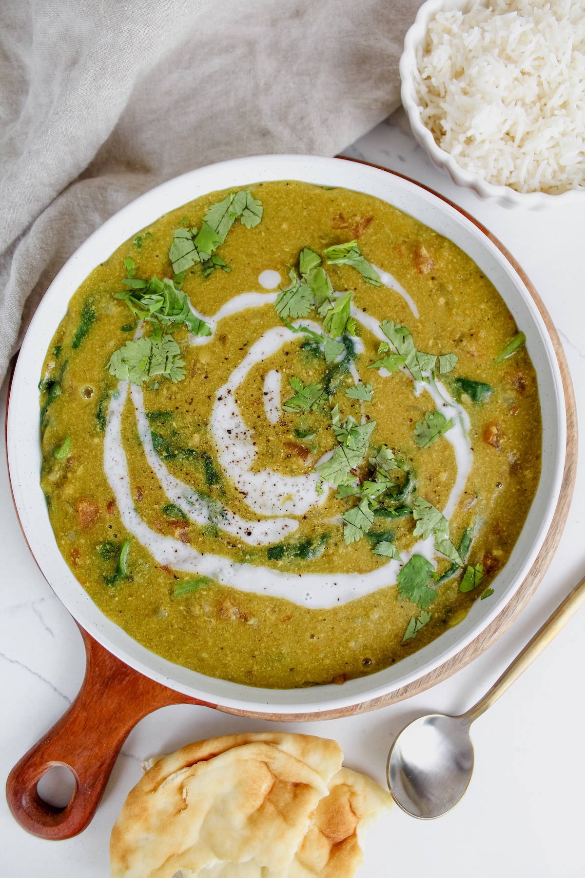 overview shot of bowl of easy red lentil dal with naan on the side