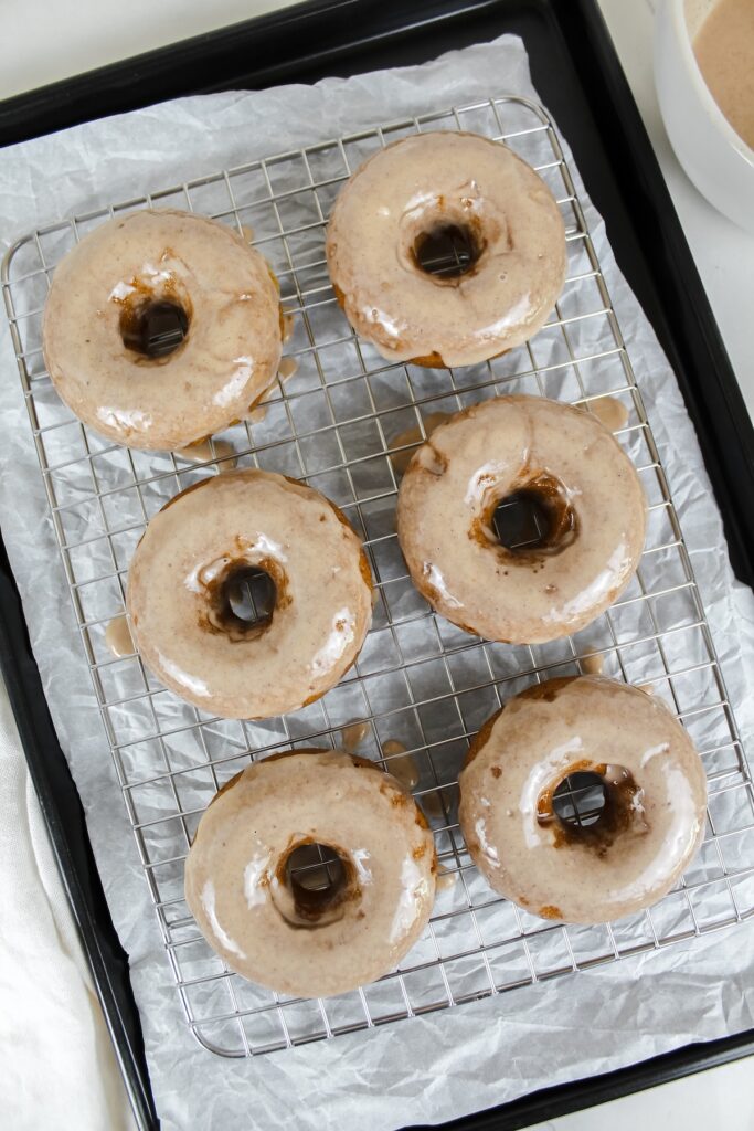vegan pumpkin donuts with maple pumpkin spice glaze on a wire rack