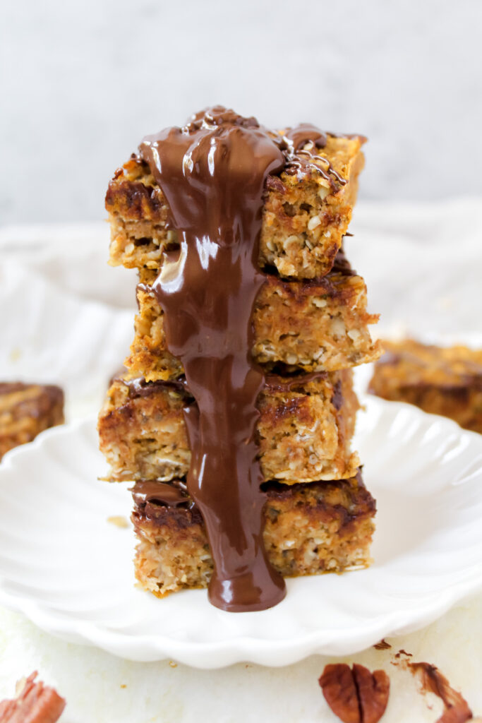 stack of pumpkin oatmeal bars with chocolate dripping down the sides
